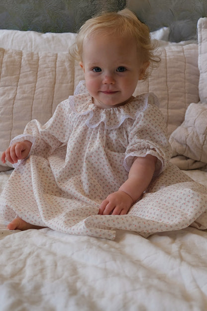 Baby wearing Harriet Jane London Briar Rose nightie in French cotton with lace trim collar, sitting up